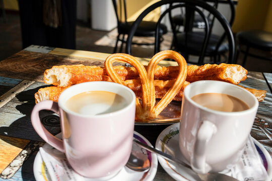 Cozy cafe breakfast with coffee and heart-shaped churros