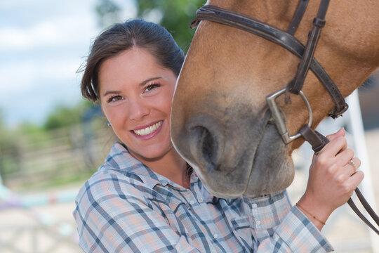 a woman holding horses head