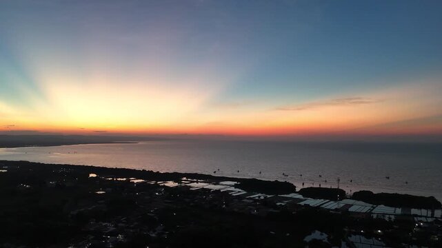 Cinematic Aerial Drone Shot of Majestic Sunrise with Crepuscular Rays over Coastline and Aquaculture Ponds