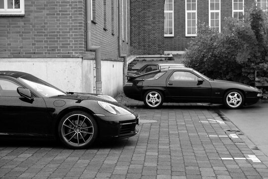 Porsche 928 der Achtzigerjahre und Neunzigerjahre und Porsche 911 oder 997 am 31.05.2026 beim Oldtimertreffen Porsche Day im Lenkwerk in Bielefeld in Ostwestfalen-Lippe in neorealistischen Schwarzwei&szlig;