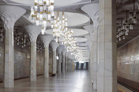Ornate marble interior of Mustaqillik Maydoni metro station in Tashkent with glass chandeliers and geometric ceiling design. Ideal for travel and architecture publications.