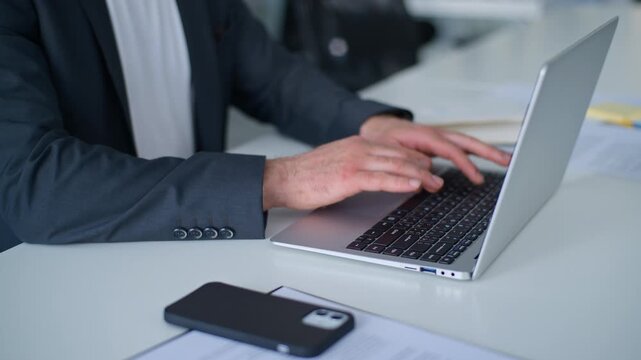 Close up male hands typing laptop chatting with e-mails in company at table unknown Caucasian business man working with computer web chat with client distant trading online job businessman in office