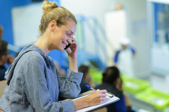 pretty student with clipboard looking at camera