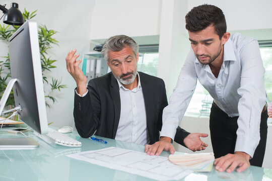 troubled architects looking at plans in office