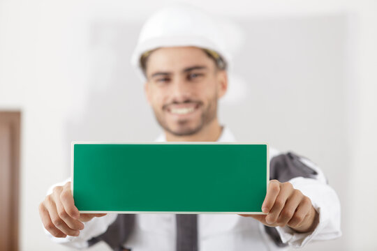 man holding wet paint sign