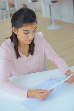 sad young woman reading letter