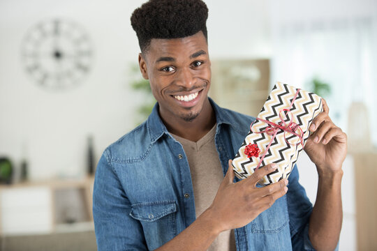 man holding a gift box in his hand at home