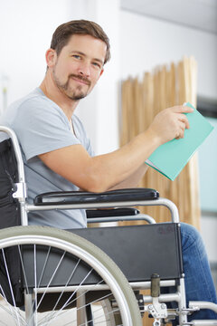 physically handicapped man in wheelchair with a book