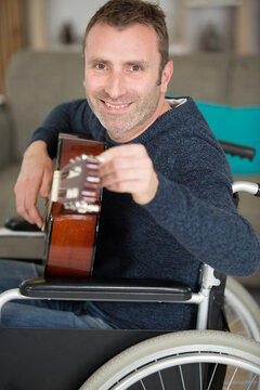 a man on the wheelchair playing the guitar