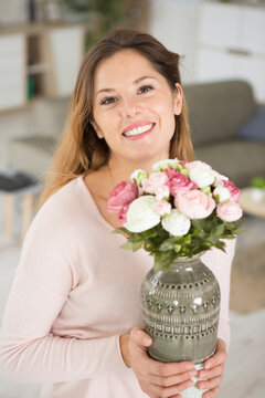close up portrait of beautiful young woman holding flowers