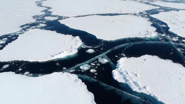 Aerial view of melting arctic sea ice floating in dark blue ocean water