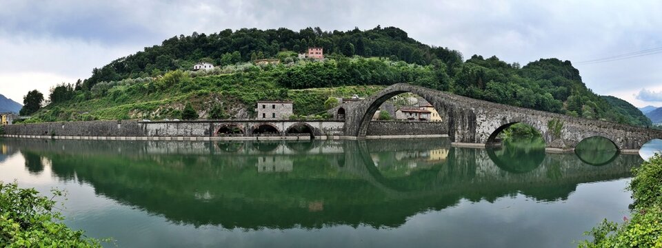 The devil's bridge or Maddalena Bridge, is a historic stone bridge with unique arches, beautifully reflected in the calm green waters of the Serchio River in Borgo a Mozzano, village of Tuscany, It