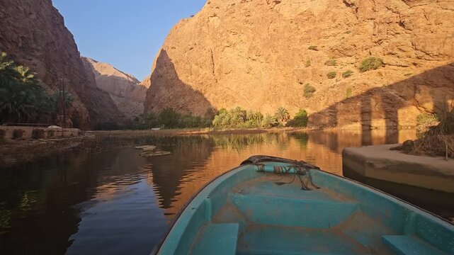 A boat sails down a river in Oman on a calm morning. Wadi Shab in Oman. Wad Shab is iconic tourist spot in Oman
