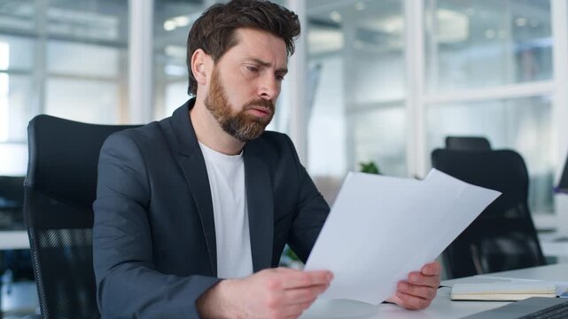 Stressed Caucasian business man reading papers bad result problem feeling headache middle-aged businessman working with documents failure work bankruptcy thinking trouble crisis in office mature male