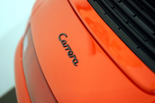 Schriftzug und Leuchtenband des Porsche 911 Carrera oder Porsche 993 in Orange der Neunzigerjahre am 31.05.2026 beim Oldtimertreffen im Lenkwerk in Bielefeld im Teutoburger Wald in Ostwestfalen-Lippe