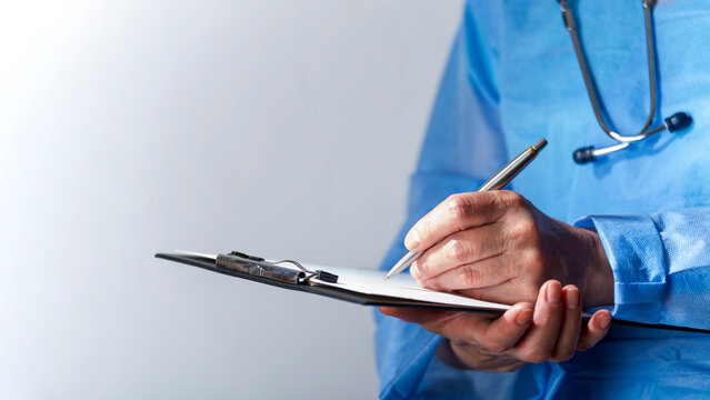 Female caucasian doctor filing papers in clipboard. Healthcare background with copy-space