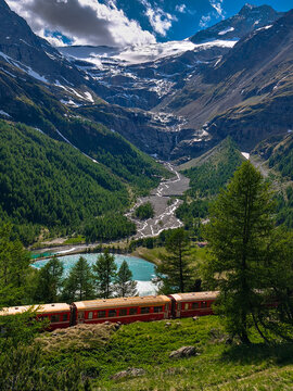 Scenic Bernina Red Train Passing Alpine Glacier Valley in the Swiss Alps