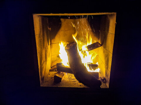 Burning Firewood in a Rustic Indoor Fireplace at Night