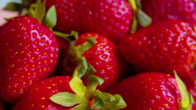 Macro close-up of ripe strawberries. Shallow depth of field, natural light. Vibrant red texture. Perfect for food advertising, healthy nutrition, organic diet and dessert.