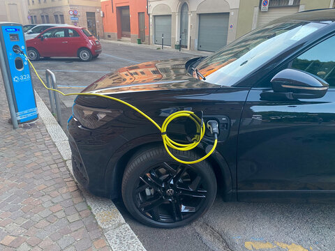 Volkswagen ID.4 electric SUV charging at an A2A station in an urban setting, promoting ecofriendly transport