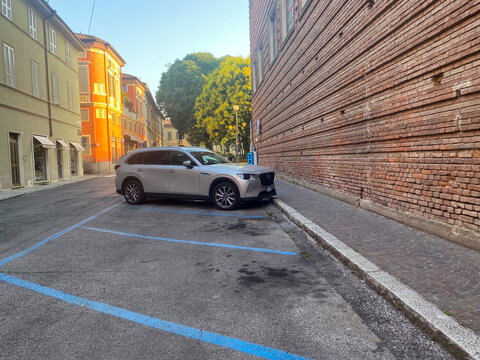Mazda CX 60 PHEV SUV parked on an urban street with blue lines near historic brick architecture