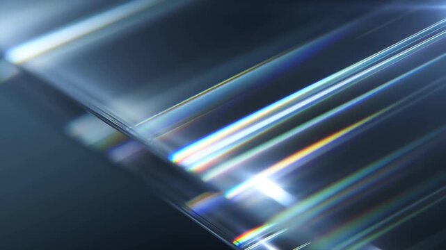 Tracking shot of light rays refracting and streaking across angled glass prism surface with slow diagonal dolly movement in dark studio environment