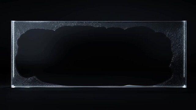 Static slow motion shot of liquid ink spreading inside rectangular glass tank on black studio background with reflective edges