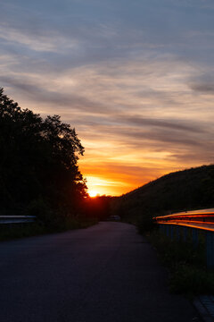 Stimmungsvoller Sonnenuntergang mit leuchtend orangefarbenem Himmel &uuml;ber einer Landschaft. Romantische Abendstimmung, Naturidylle und beeindruckendes Farbenspiel. Echtfoto.