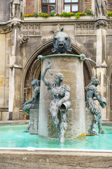 Obraz premium Historic fish fountain sculpture at Marienplatz in Munich with Gothic architecture backdrop