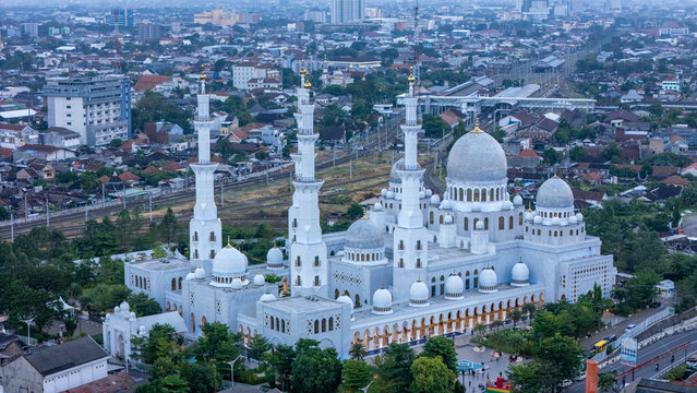 Aerial view of the Sheikh Zayed Grand Mosque with white marble domes and minarets in the urban landscape of Surakarta, Jawa Tengah, Indonesia.