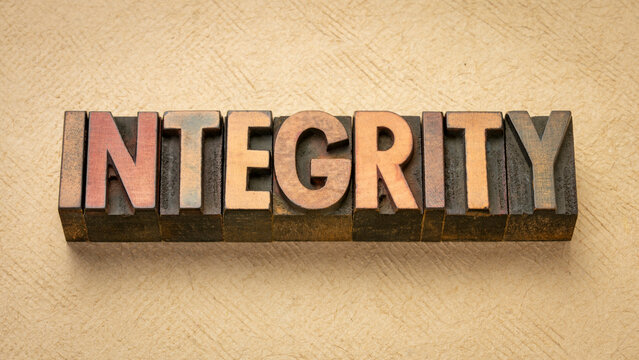 integrity - word abstract in vintage letterpress wood type blocks against art paper
