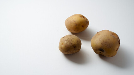 Fototapeta premium Three Potatoes Clustered on White Background