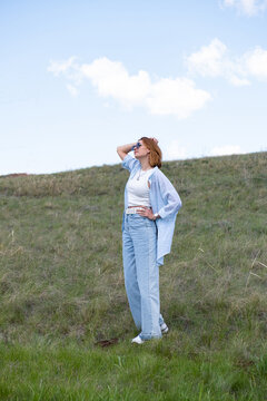 Woman Walking in a Green Field on Rolling Hills, Embracing Freedom and Nature. good enough in indfulness, simplicity or mental health, relaxation at low desire living,  realistic goals. adequate