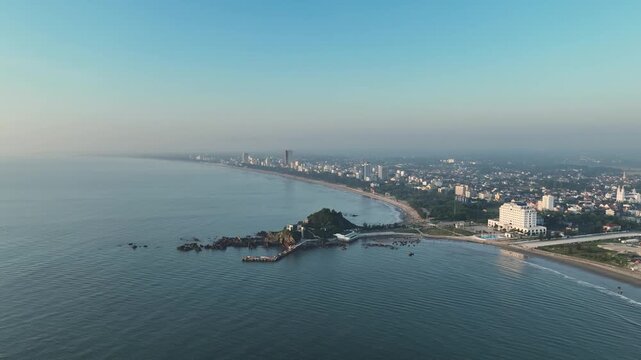 High aerial panorama of Lan Chau Island and the sweeping coastline of Cua Lo under morning haze.