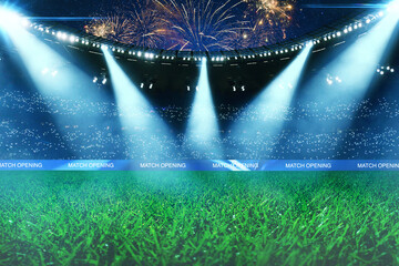Empty green soccer field of a huge stadium with bright spotlights, fans in the stands and spectacular fireworks in the night sky during a match opening ceremony. Professional sport arena background. © alones