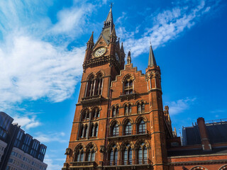 Fototapeta premium Historic St Pancras Station Clock Tower Under Blue Sky in London UK