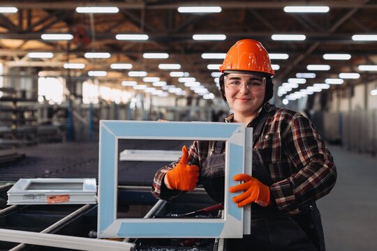 Female worker holding pvc window frame giving thumbs up