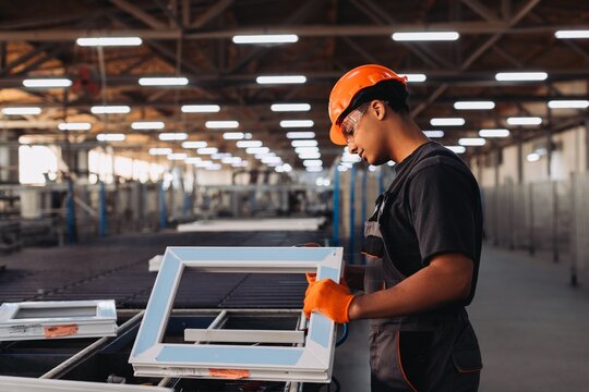 Worker inspecting pvc window frame production line