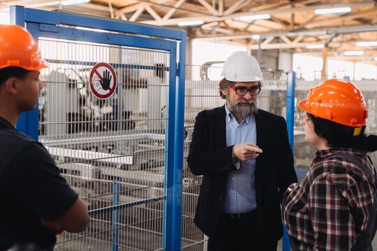 Factory manager discussing production with industrial workers