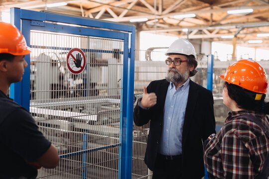 Factory manager talking with workers during inspection