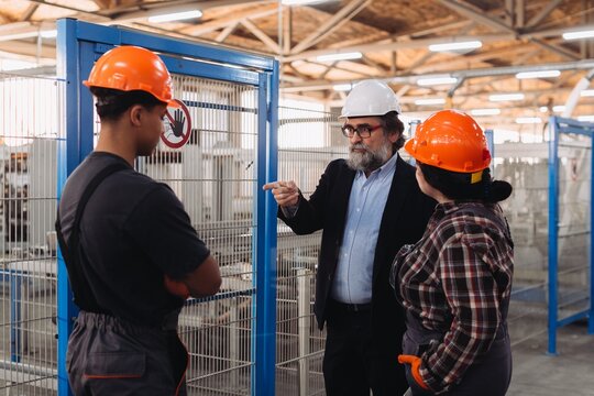 Foreman instructing workers in factory production area