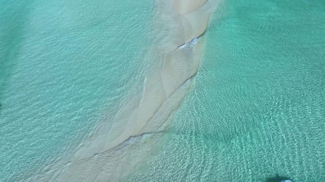 Aerial view of a pristine white sandbar surrounded by crystal clear turquoise ocean water in Fulhadhoo, Baa Atoll, Maldives.