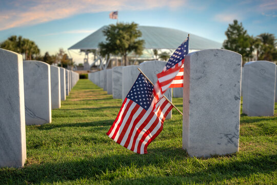 Memorial Day concept. Sarasota National Cemetery with rows of white tomb stones and USA flag on green grass