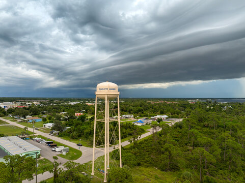 Tropical rainstorm above Charlotte Harbor water tower. Dramatic sky with dark clouds and heavy summer downpour in Florida.