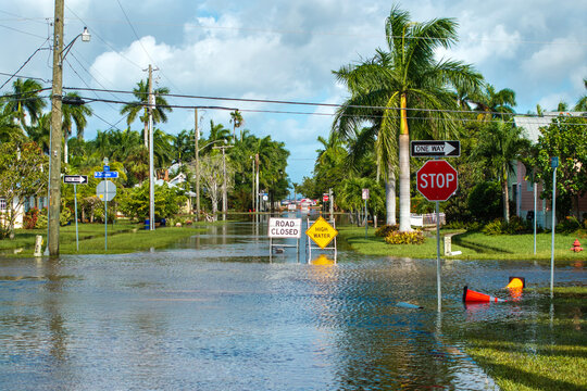 Hurricane Milton flooded street with road closed sign blocking driving of cars in Punta Gorda, Florida. Safety of transportation during natural disaster concept