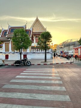 Sunset Over Bangkok Street Near Wat Suthat Temple Area with Pedestrian Crossing