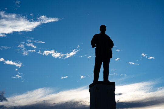 Silhouette of a Statue Against a Vibrant Sky: A Striking Contrast of Shadows and Clouds in the Late Afternoon Sunlight