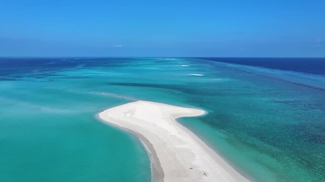 Aerial view of a pristine white sandbar surrounded by turquoise lagoon waters and coral reefs in Fulhadhoo, Baa Atoll, Maldives.