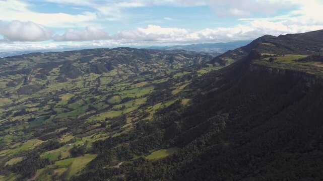 Drone aerial view Mountain piedra colgada, Colombia Latin America, tree zone forest nature area, blue sky 4k