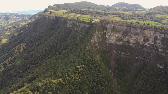 Drone aerial view Mountain piedra colgada, Colombia Latin America, tree zone forest nature area, blue sky 4k